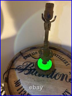 This vintage 1920s table lamp features a on a glowing green uranium slag base