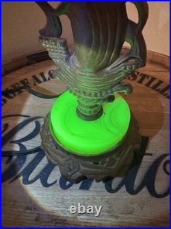 This vintage 1920s table lamp features a on a glowing green uranium slag base