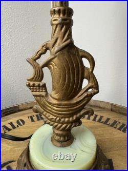 This vintage 1920s table lamp features a on a glowing green uranium slag base