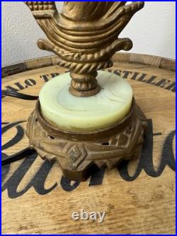 This vintage 1920s table lamp features a on a glowing green uranium slag base